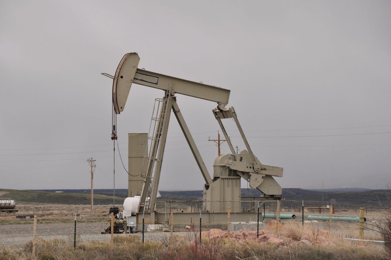 Pump jack standing on dry prairie grassland