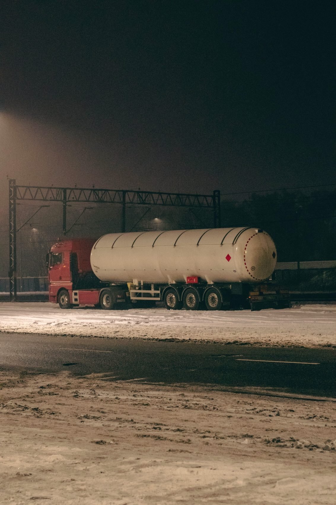 Tanker trailer parked under lights at night