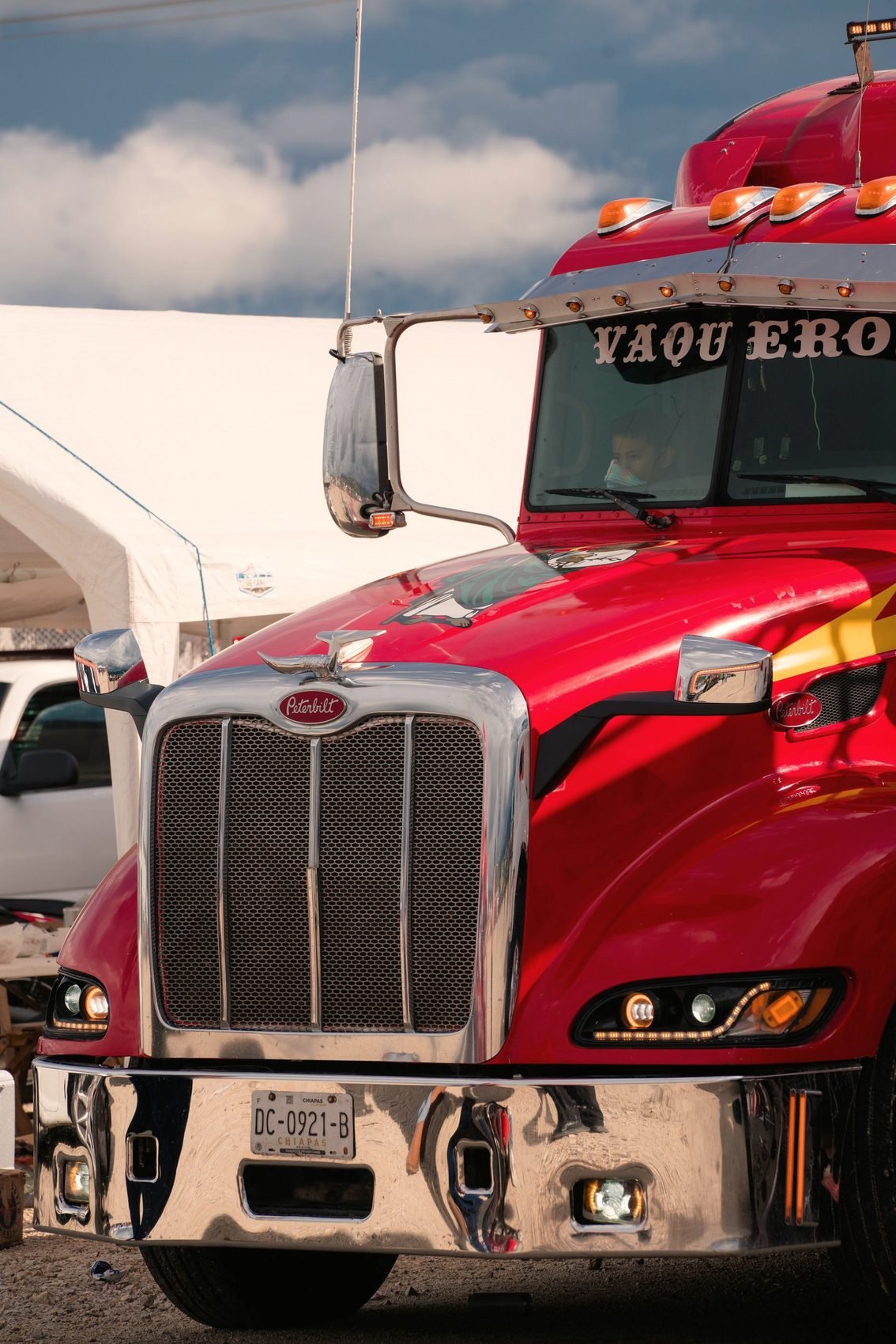 Close view of a chrome truck grille and headlight